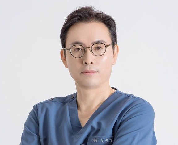 김동준 대표원장 — 푸른 수술복 상반신(가슴에 작은 수놓은 이름)